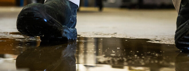 A worker in a warehouse walking in spilled liquid.