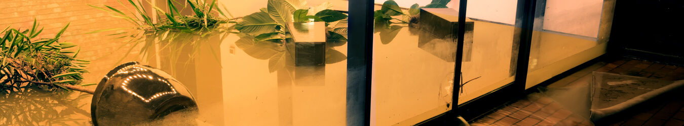 Water flowing through doors from a flooded office.