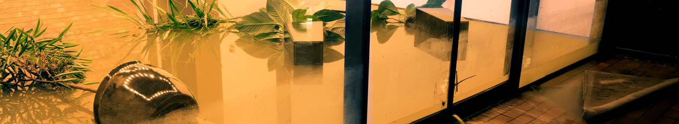 Water flowing through doors from a flooded office.