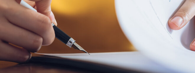 Woman signing document.