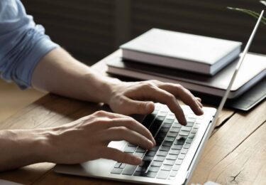 Close up businessman using laptop, sitting at work desk